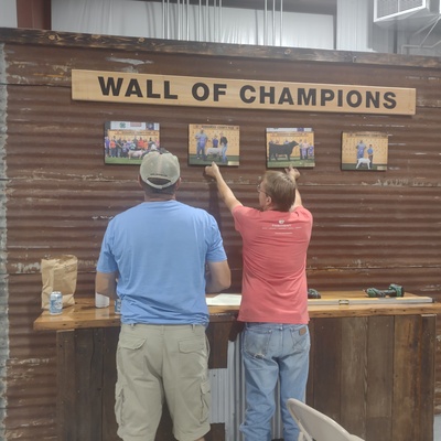 Wall of Champions - volunteers creating display highlighting 4-H exhibitors